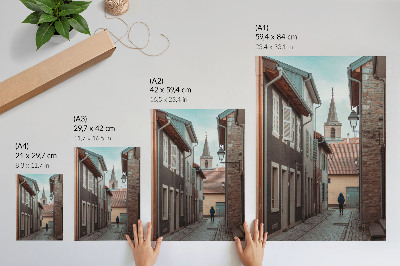 Plakat Uska ulica, stambene kuće, toranj, plavi kaput
