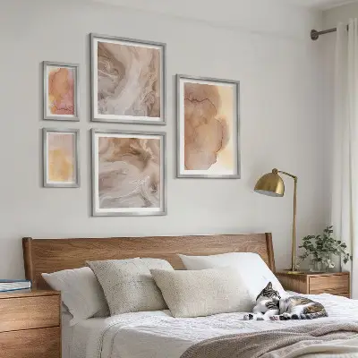 Set slika iznad kauča s toplim akvarelnim teksturama u boji