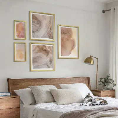 Set slika iznad kauča s toplim akvarelnim teksturama u boji