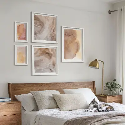 Set slika iznad kauča s toplim akvarelnim teksturama u boji